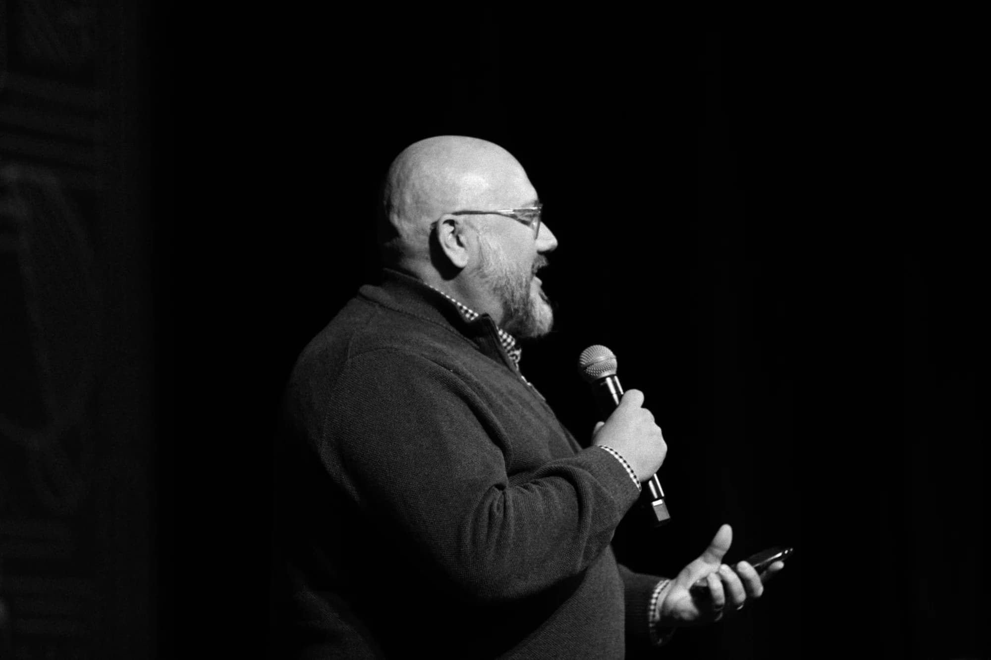 Nils Smith speaking on stage with a microphone
